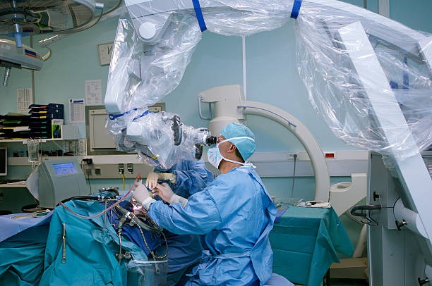 Neurosurgeons performing an operation using a surgical microscope and intraoperative imaging in a sterile operating room